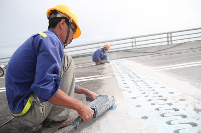 C&ocirc;ng nh&acirc;n đang ch&ugrave;i rửa, m&agrave;i dũa mặt cầu trước giờ th&ocirc;ng xe